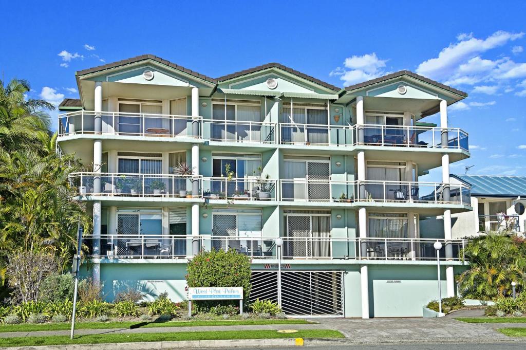 a large apartment building with balconies and trees at Westport Palms 14 Buller Street in Port Macquarie