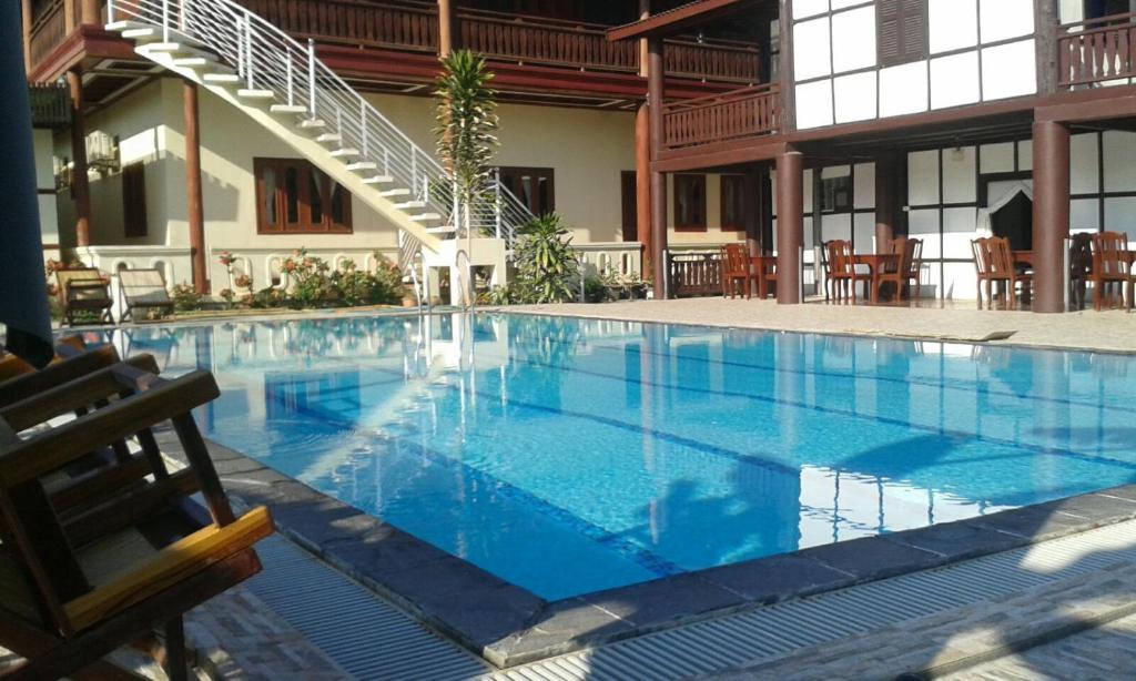 a large blue swimming pool in a building at Kongmany Colonial House in Muang Không