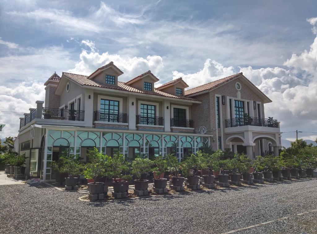 uma casa com um monte de vasos de plantas na frente dela em YiShan Farm Homestay em Checheng