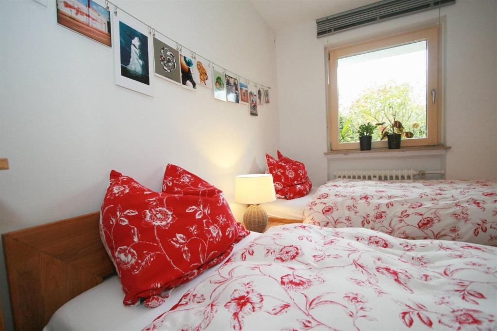 a bedroom with two beds with red pillows and a window at Ferien bei Naus - Ferienwohnung in Marburg an der Lahn