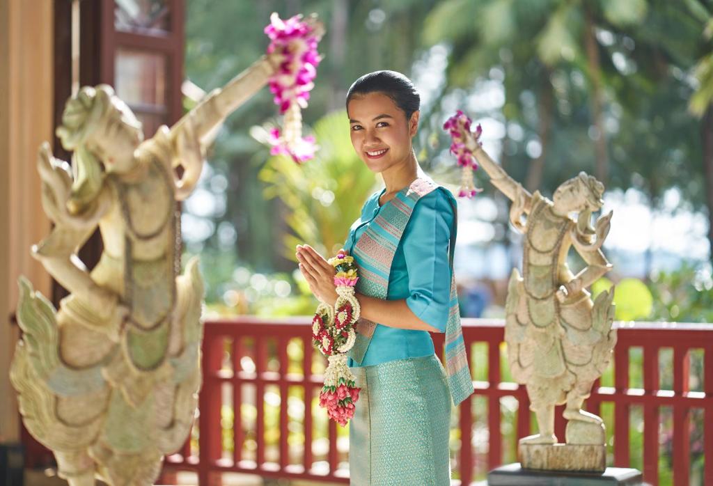 a woman is standing next to a statue at Dusit Thani Laguna Phuket in Bang Tao Beach