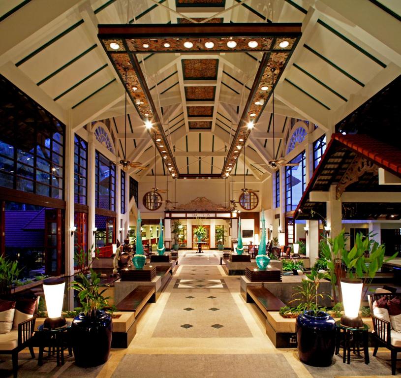 a lobby of a hotel with chairs and plants at Dusit Thani Laguna Phuket in Bang Tao Beach