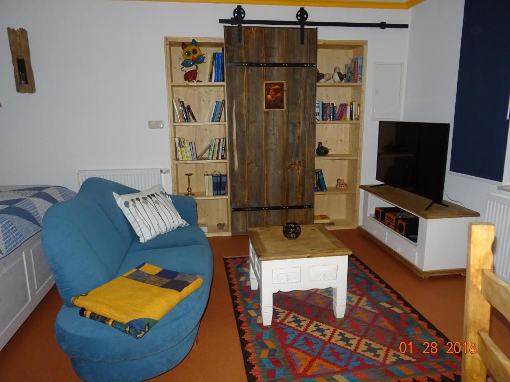 a living room with a blue couch and a table at Zur Scheune in Ilmenau