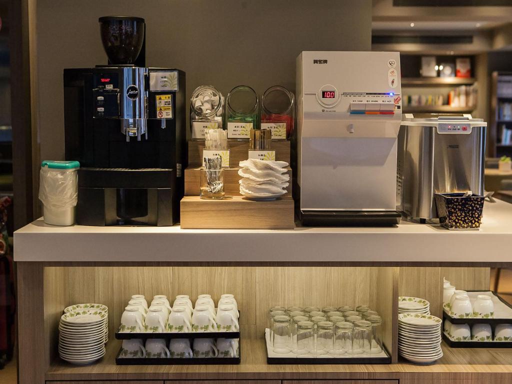 a counter with a coffee maker and a refrigerator at Royal Inn Taipei Linsen - Huashan 1914 Creative Park in Taipei