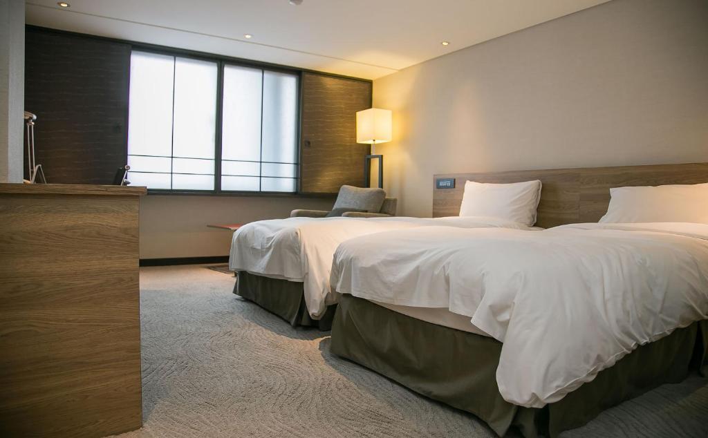 Postel nebo postele na pokoji v ubytování Royal Inn Taipei Nanxi - MRT Zhongshan Station