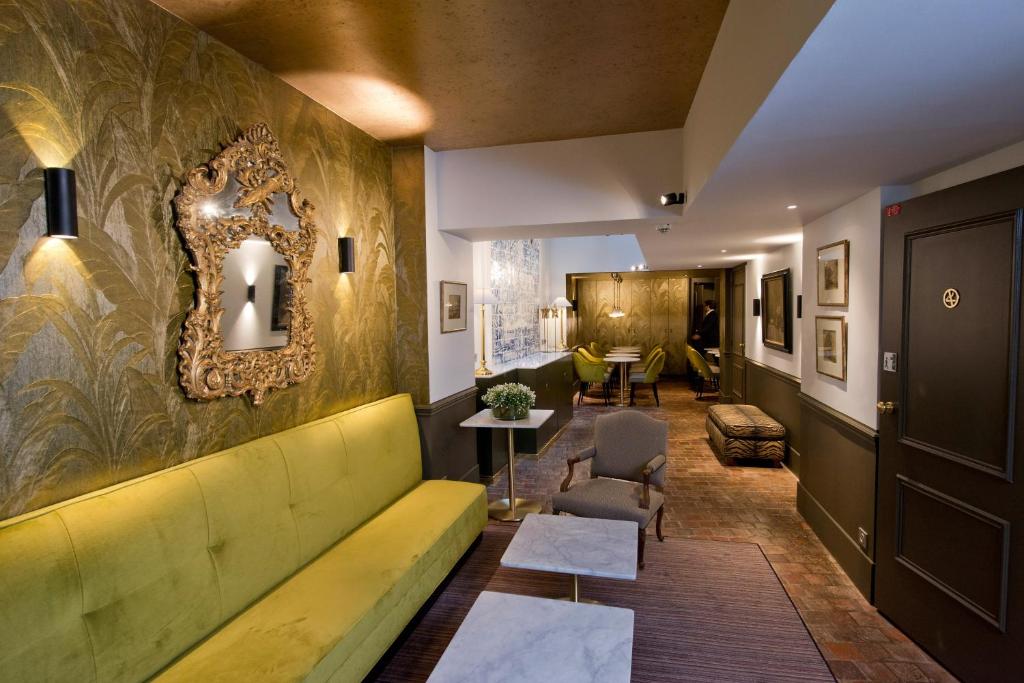 a lobby with a yellow couch and a table at Hôtel Henri IV Rive Gauche in Paris