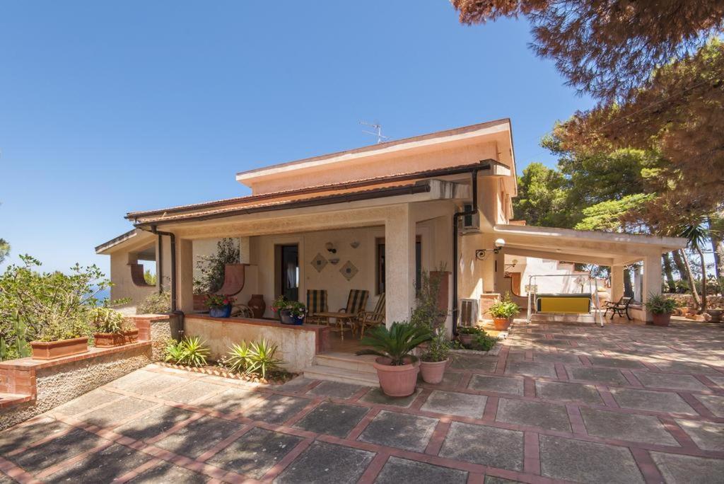 ein kleines Haus mit einer Terrasse und einigen Pflanzen in der Unterkunft Holiday Home Cala Bianca in Castellammare del Golfo
