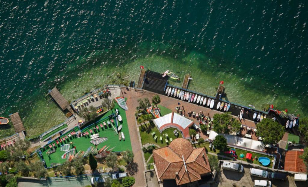 eine Luftansicht eines Resorts neben dem Wasser in der Unterkunft Surf Hotel Pier - Montagnoli Group in Limone sul Garda
