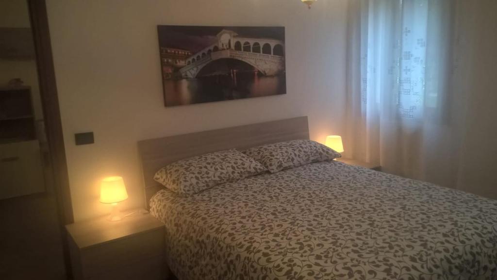 1 dormitorio con 1 cama y 2 lámparas en las mesas en Marina Venice Apartment en Mira