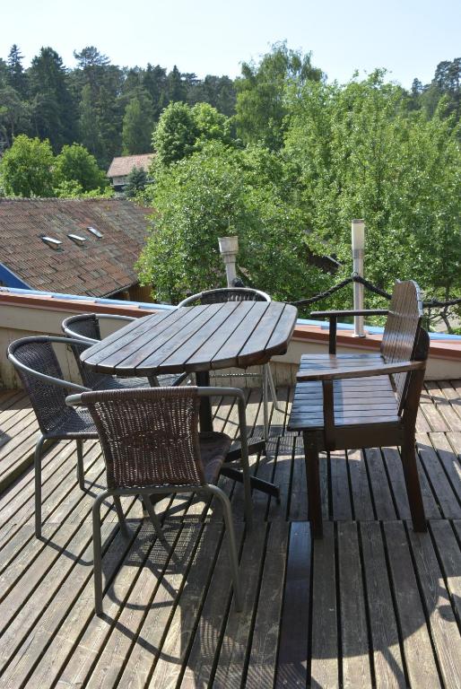 a wooden deck with a picnic table and chairs at Neringaholiday Apartamentai in Juodkrantė