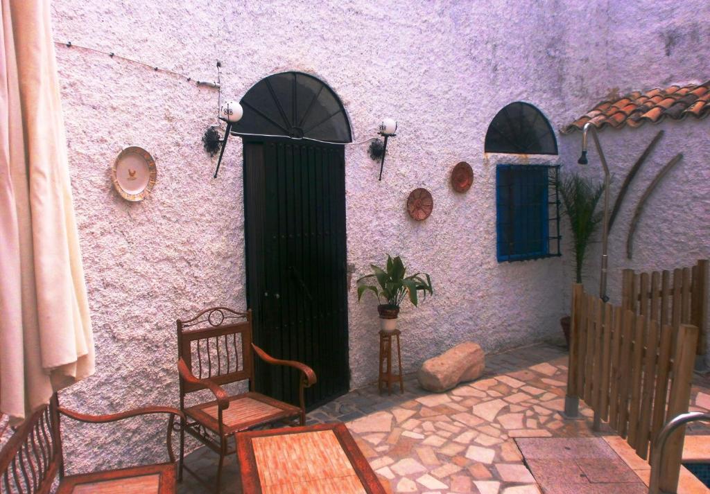 un edificio púrpura con 2 sillas y una puerta en La Serrana, en Bedmar