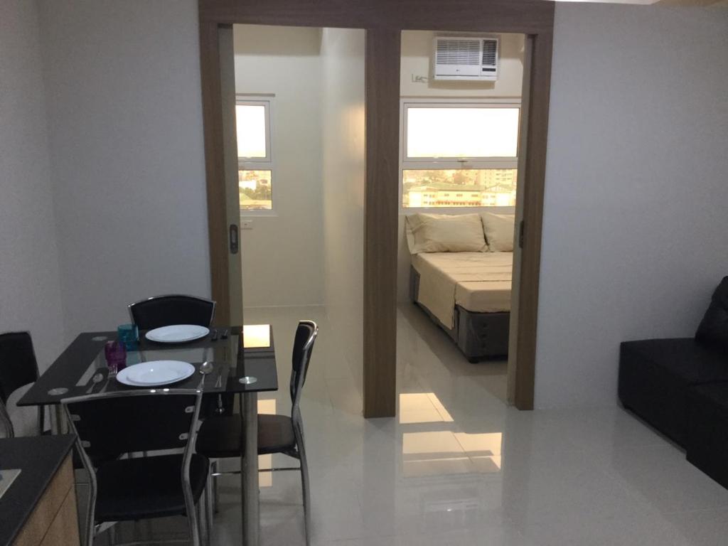 uma sala de estar com uma mesa e uma cama em Jhocson Residences em Manila