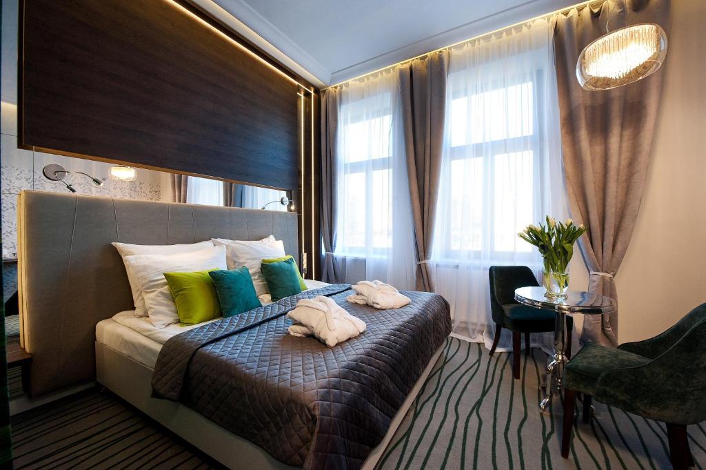 a hotel room with a bed with towels on it at Plaza Boutique Hotel in Kraków