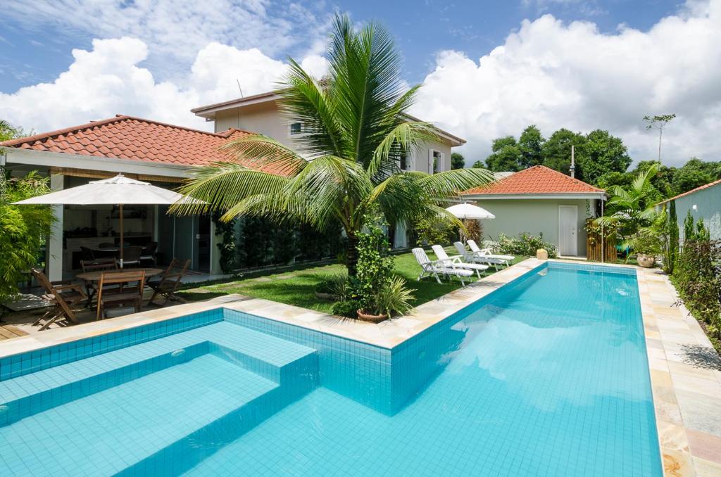 a swimming pool in front of a house at Casa Clara Paraty in Paraty