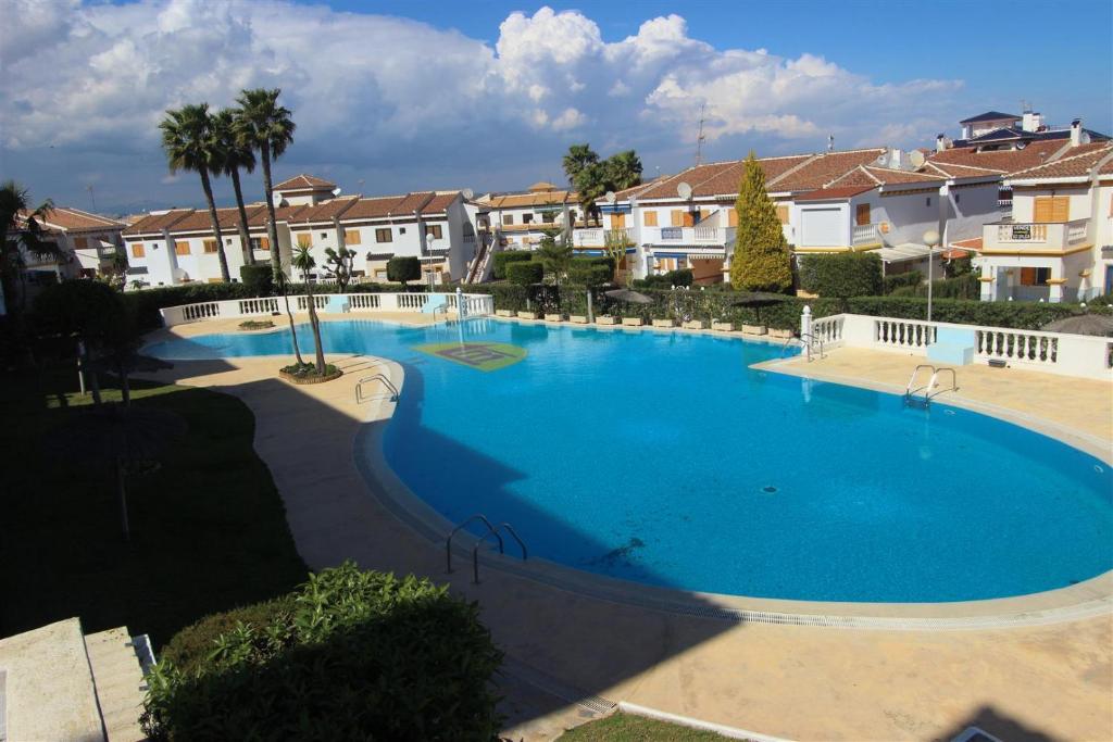 ein großer blauer Pool mit Häusern im Hintergrund in der Unterkunft La Mata Studio 4645 in La Mata