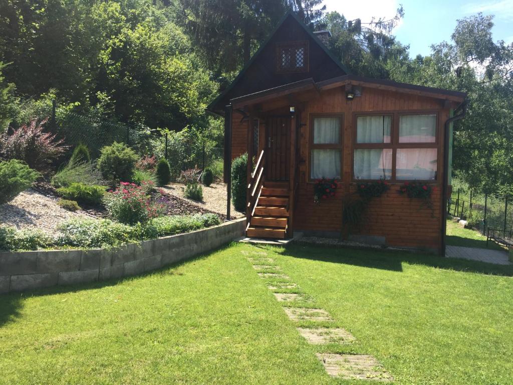 a small wooden cabin in a yard with a green lawn at CHataBela in Svit