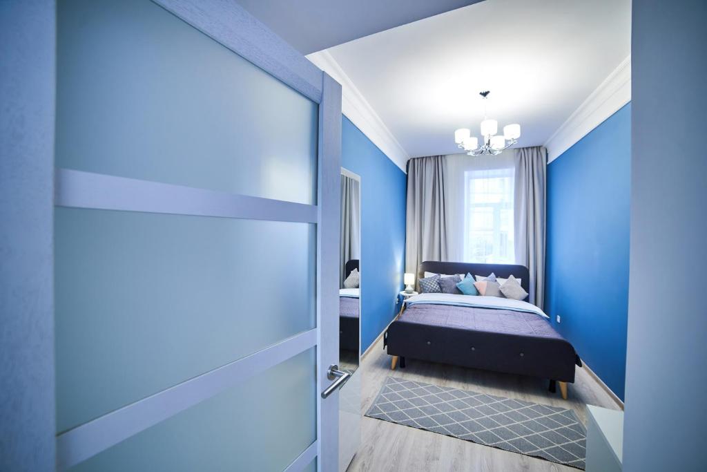 リヴィウにあるRomantic Apartment in the Сity Сenterの青いベッドルーム(ベッド1台、窓付)