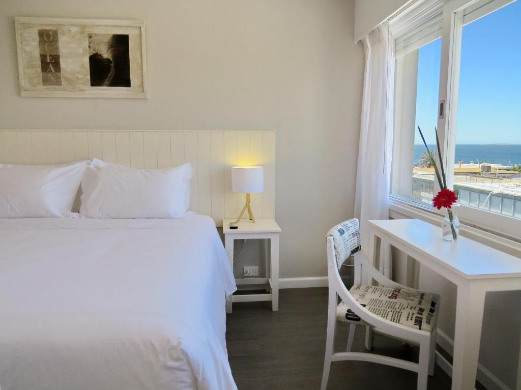 sypialnia z łóżkiem, biurkiem i oknem w obiekcie Atlántico Boutique Hotel w mieście Punta del Este