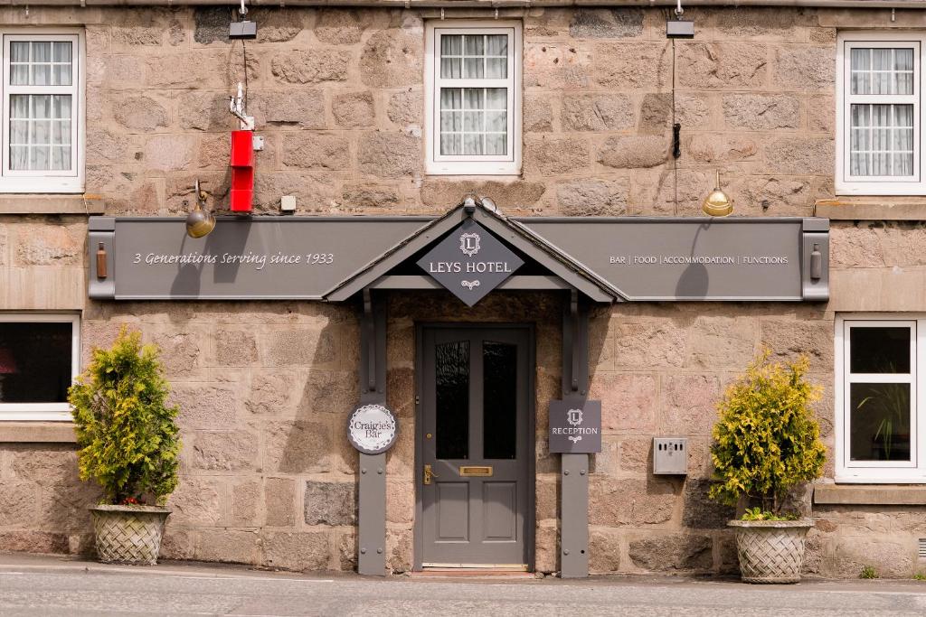 un edificio de piedra con una señal sobre una puerta en Leys Hotel en Aberdeen