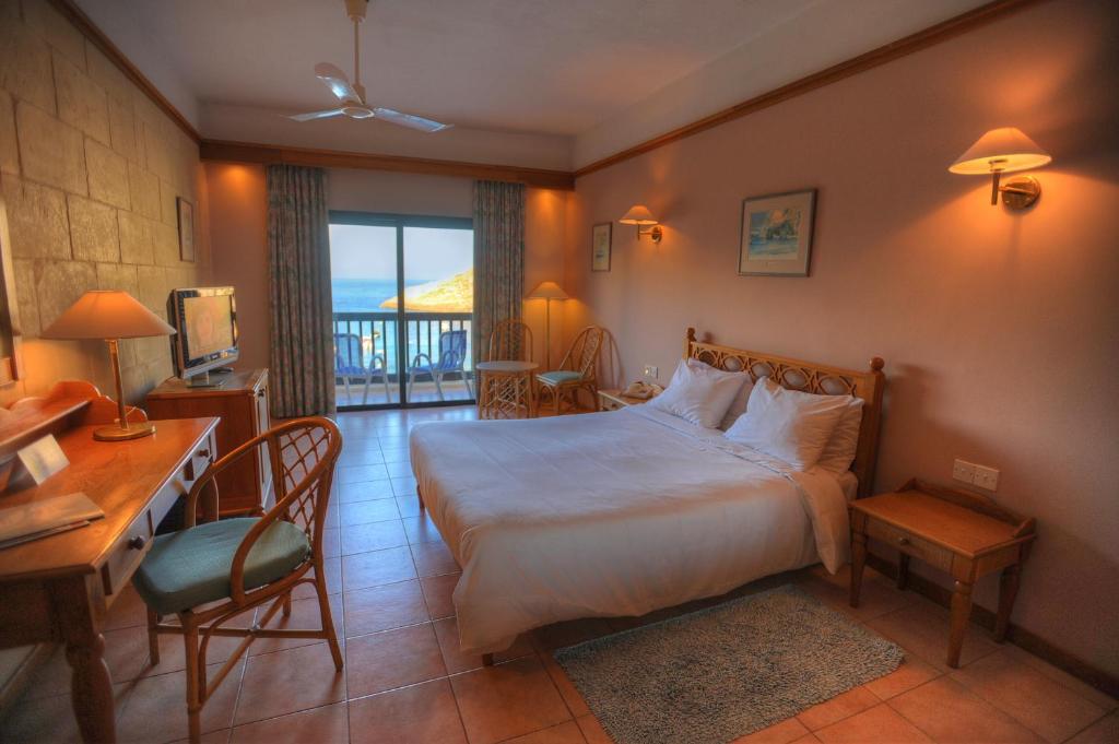 a hotel room with a bed and a desk and a desk at St. Patrick's Hotel in Xlendi