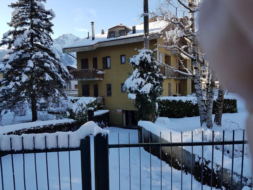 uma cerca em frente a uma casa coberta de neve em Home Cremeno Valsassina em Cremeno