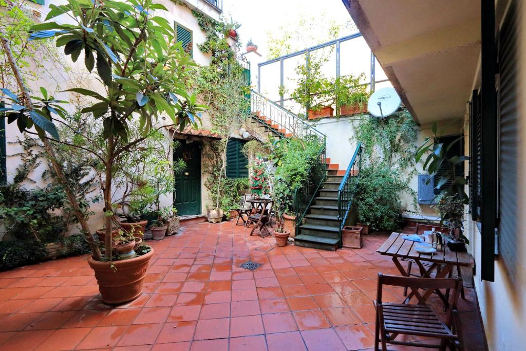 ローマにあるCharacteristic apartment just beside the Vaticanの植物と階段、テーブルと椅子のある中庭