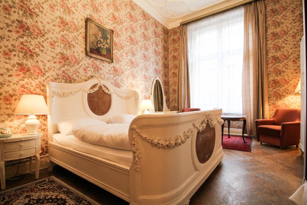 a bedroom with a white bed and floral wallpaper at Hotel-Pension Funk am Kurfürstendamm in Berlin