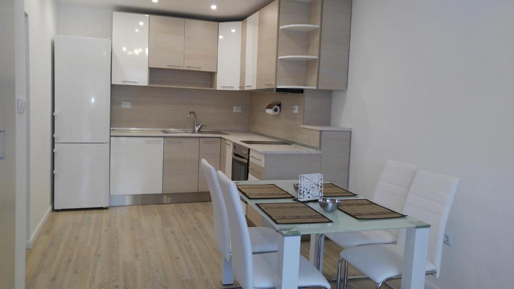 cocina con mesa, sillas y nevera en Modern apartment Sofia center, en Sofía