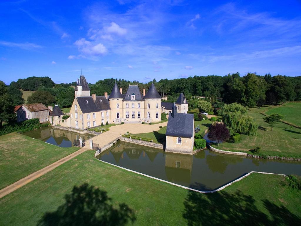 - une vue aérienne sur un grand château avec un lac dans l'établissement Château de Vaulogé, à Fercé-sur-Sarthe