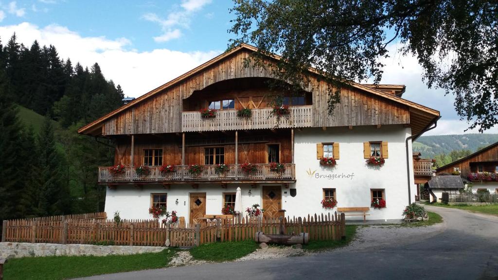 een groot wit huis met een hek ervoor bij Bruggerhof Prags in Braies