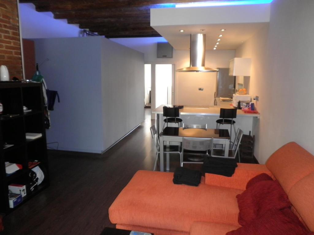 バルセロナにあるBacrou apartment, design loft near the seaのリビングルーム(オレンジ色のソファ付)、キッチンが備わります。
