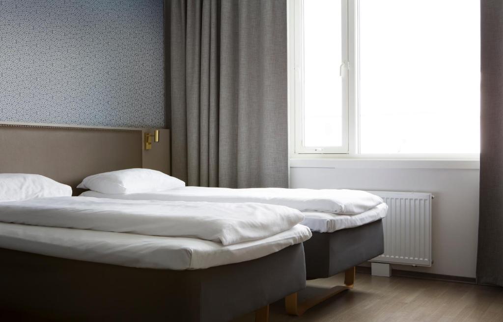 Un pat sau paturi într-o cameră la Comfort Hotel Xpress Tromsø