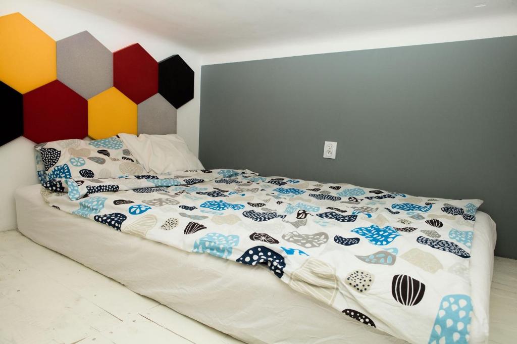 a bed with a colorful bedspread on top of it at Apartament Żelazna in Warsaw