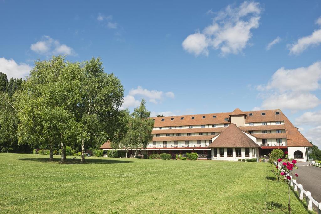 a large building with a grass field in front of it at Best Western Plus l'Orée Paris Sud in Saulx-les-Chartreux