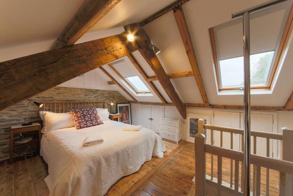 a bedroom with a bed in a room with windows at Fernleigh Cottage in Boscastle