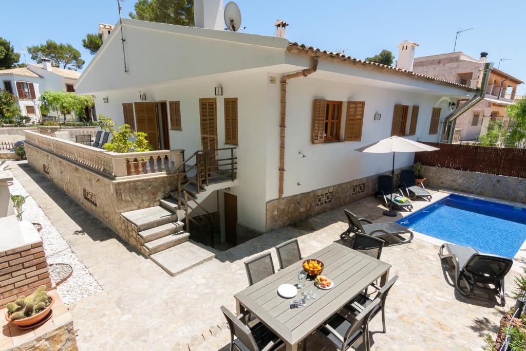 una villa con piscina, tavolo e sedie di Mar Blava House a Playa de Muro