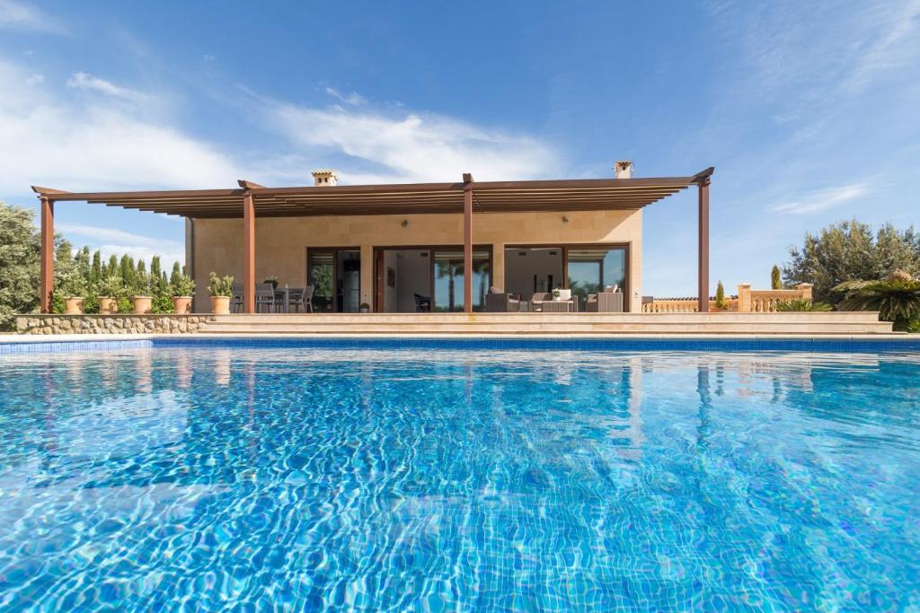 une maison avec une piscine en face d'une maison dans l'établissement Es Rasquell, à Inca