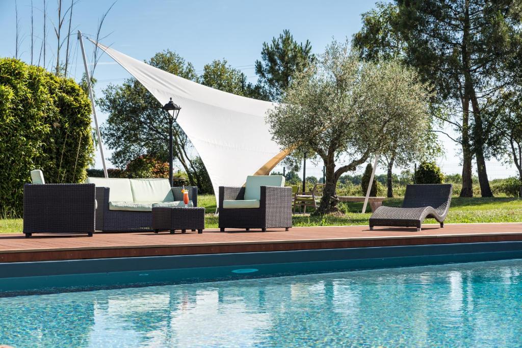 a group of chairs sitting next to a swimming pool at Logis L'Abreuvoir in Héric