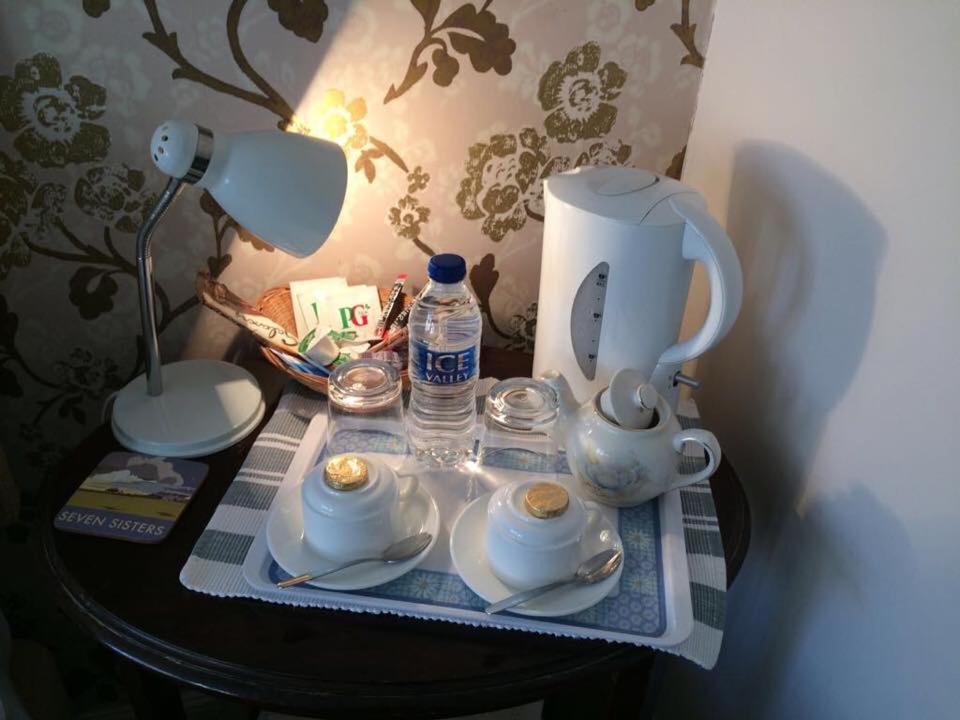 a table with a tea kettle and cups and a lamp at Beachy Rise in Eastbourne