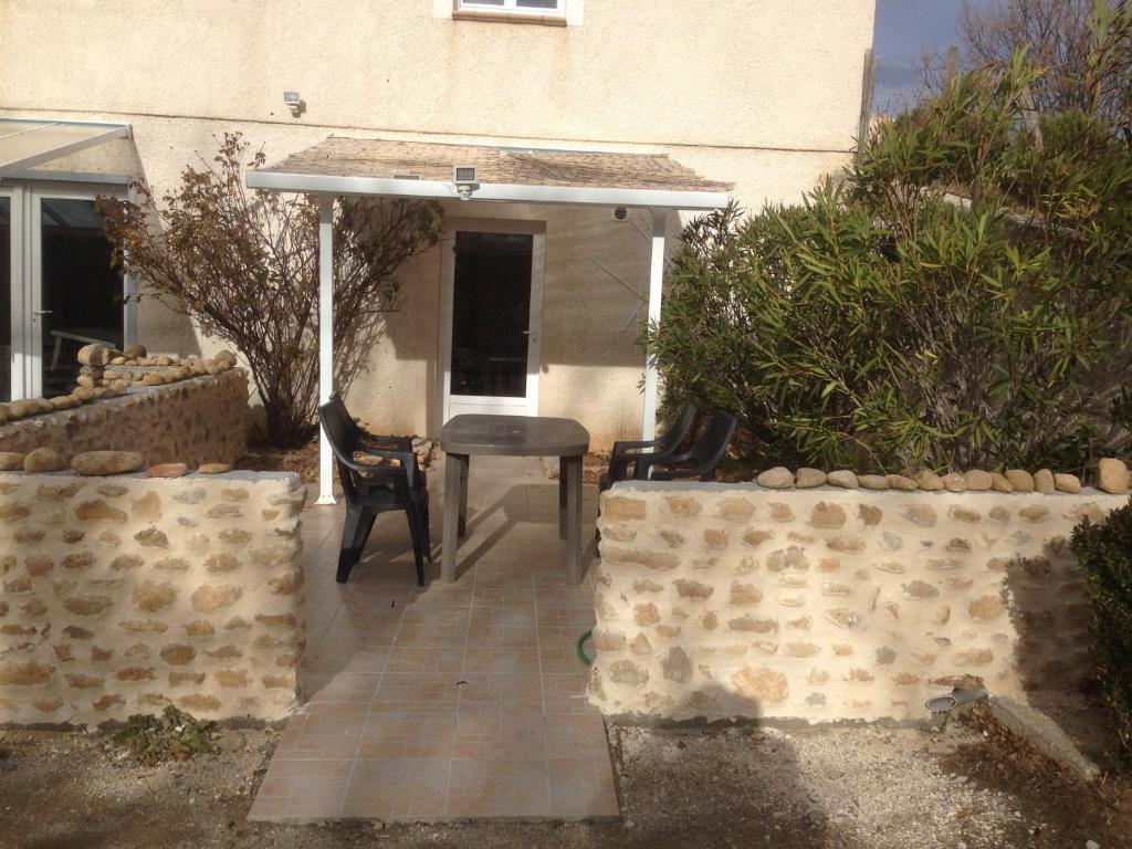 a patio with two chairs and a table in front of a building at Gorges du Verdon - Lac Sainte-Croix in Montagnac