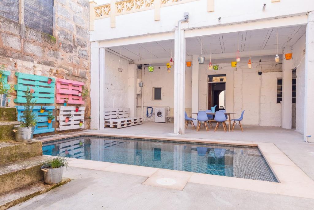 a swimming pool in a building with a table and chairs at La Penya in Sa Pobla