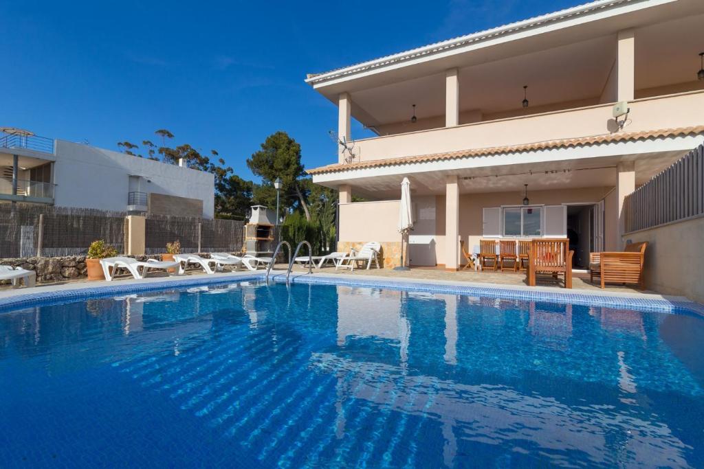 a swimming pool in front of a house at Jeronimo in Playa de Muro