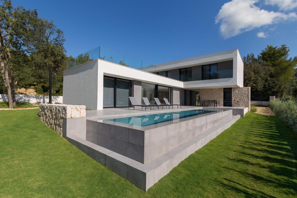 une maison moderne avec une piscine dans l'arrière-cour dans l'établissement Sol Crestatx, à Crestatx