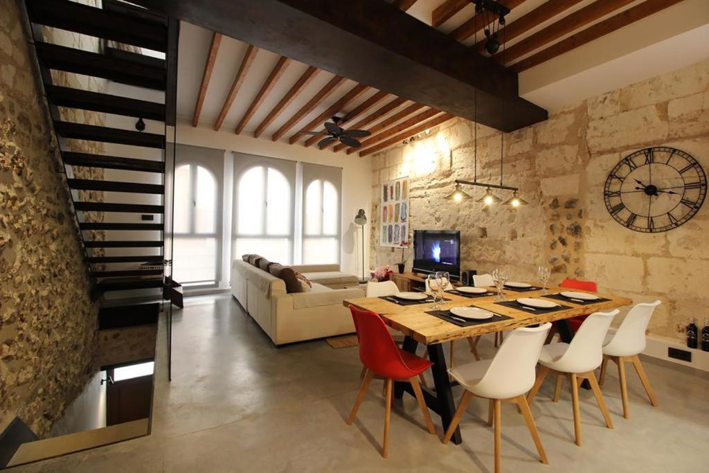 a dining room with a table and chairs and a couch at Casa Mercat in Sa Pobla