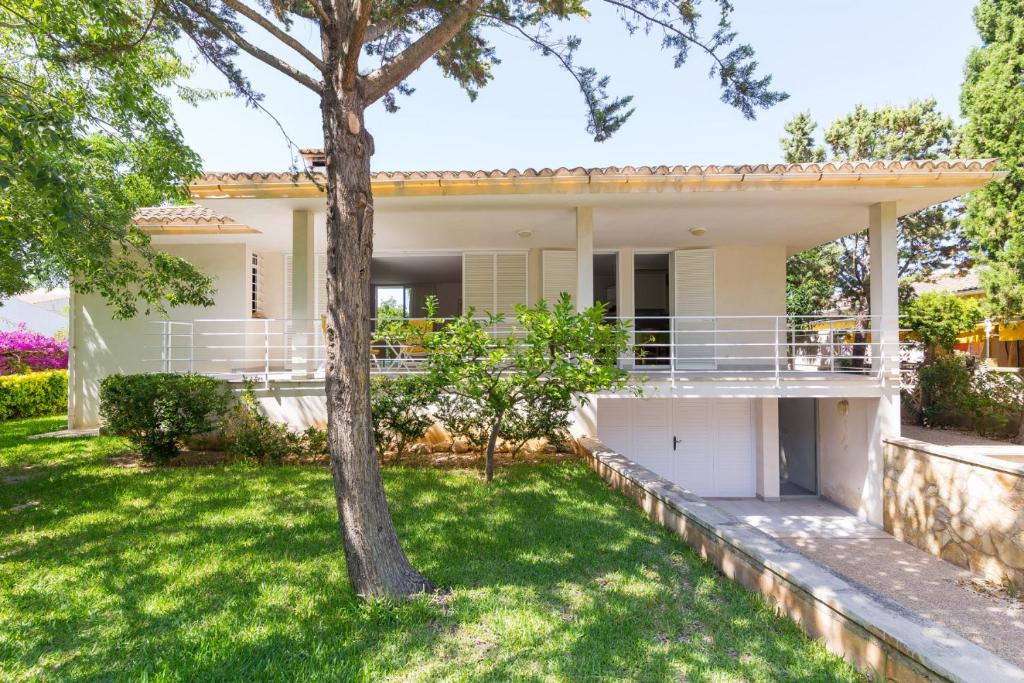 una casa con un césped verde delante de ella en Mollet, en Puerto de Alcudia