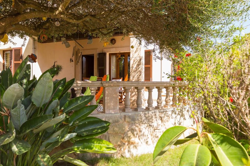 a house with a white fence and some plants at Alga Marina in Son Serra de Marina