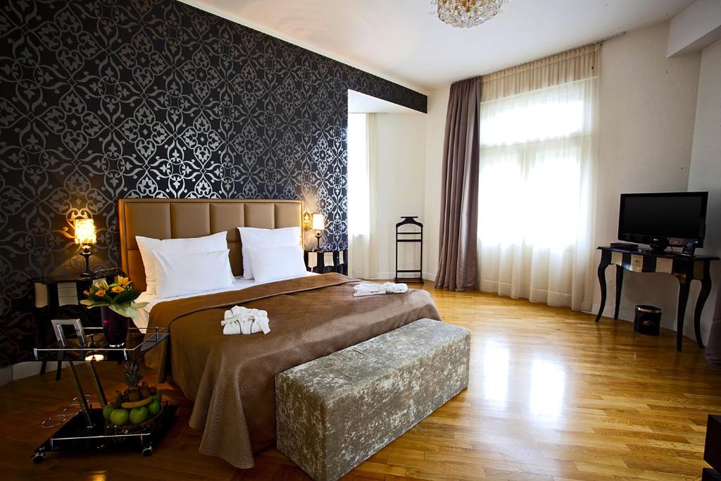 a bedroom with a large bed and a television at Deminka Palace in Prague