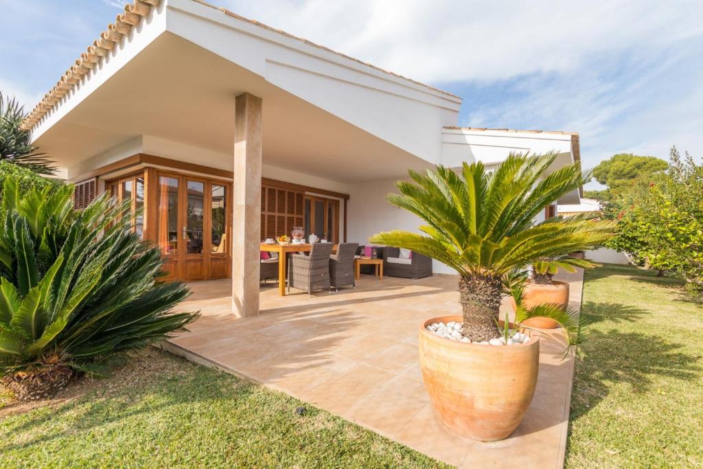 a house with a courtyard with palm trees at Margarita Pins in Playa de Muro