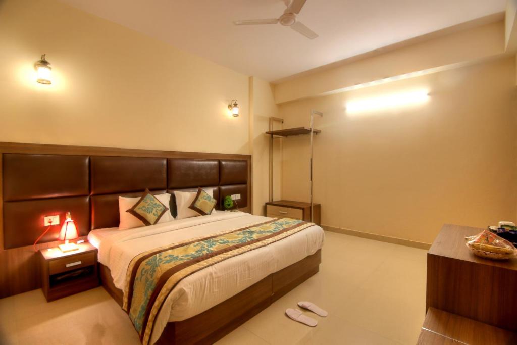 1 dormitorio con 1 cama grande y cabecero marrón en Atithi Suites - An AHG Hotel, en Greater Noida