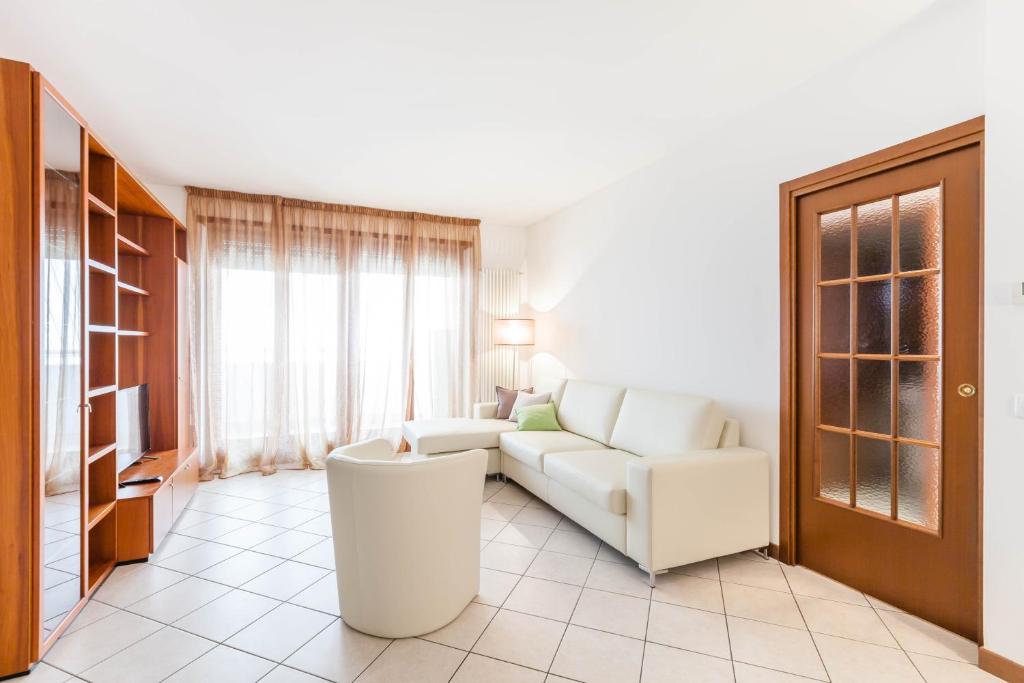 a living room with a white couch and a tv at Attico Ai Cedri in Verona